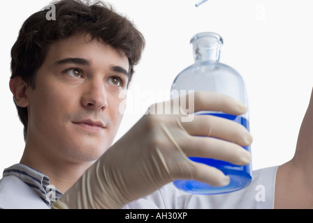 Nahaufnahme eines Wissenschaftlers hält eine Flasche mit einer pipette Stockfoto