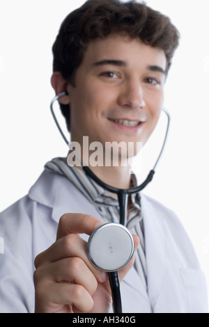 Porträt eines jungen männlichen Arztes halten ein Stethoskop und lächelnd Stockfoto