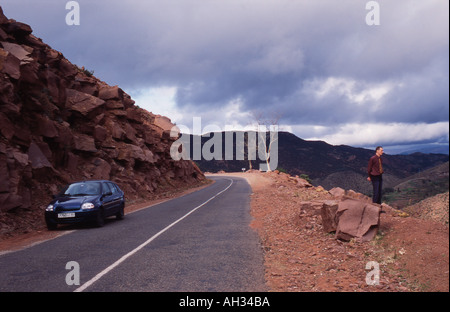 Mann und ein Auto auf einer Bergstraße Stockfoto