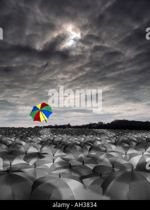 weiten Meer der schwarzen und weißen Sonnenschirmen mit einem silberweiße farbige man fliegen in den Himmel Regen Stockfoto