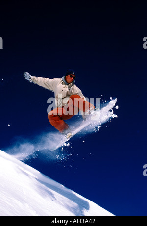 Snowboarder kommen aus einem Bergrücken in ein grab Stockfoto