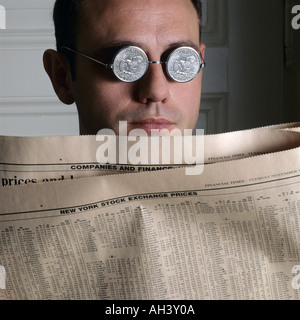 PORTRÄT EINES MANNES MIT US-DOLLAR-MÜNZE-BRILLE UND FINANZZEITUNG Stockfoto