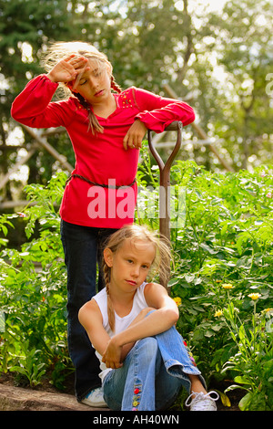 Zwei Mädchen aus Gartenarbeit ruhen Stockfoto