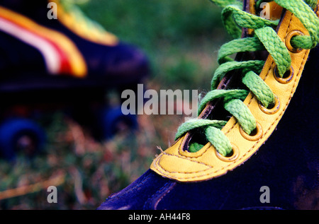 Dunkel blau Rollerblades mit gelben trimmen und helles lindgrün lases auf den Rasen horizontalen Stockfoto