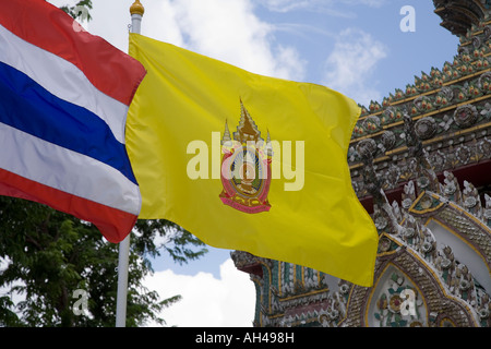 Die gelbe Flagge von König Bhumibol Adulyadej aus Thailand fliegt am Wat Pho in Bangkok, Thailand, neben der rot-blauen und weißen thailändischen Flagge. Stockfoto