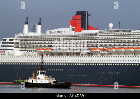 Queen Mary 2 Cunards Flaggschiff Kreuzfahrtschiff am Southampton Water mit Schlepper Redbridge England UK Stockfoto