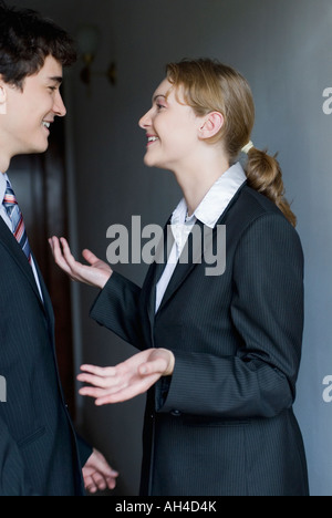 Seitenprofil eine Geschäftsfrau und ein Geschäftsmann schauen einander an und Lächeln Stockfoto