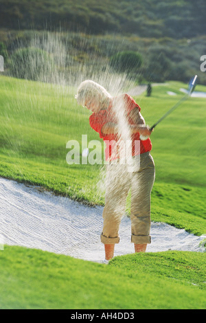 Frau Golfer Strahlen schoss aus Sandfang oder bunker Stockfoto