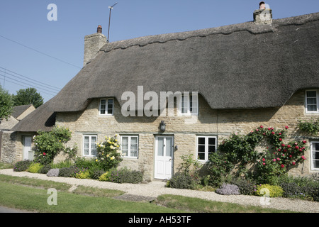 Eine strohgedeckte Hütte mit Rose um Tür in Cotswold Dorf der Minster Lovell Stockfoto