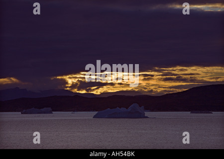 Eisberge auf einem sehr ruhigen Meer gegen dramatischen Sonnenuntergang & Küste in der Davis-Straße in der Nähe von Ilulissat aus West Küste von Grönland Stockfoto