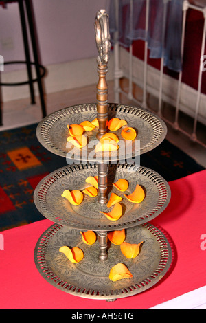 Essaouira, Marokko Riad El Madina Hippie Hotel, typisch marokkanischen afrikanischen Metall dekorative Etagere mit orange Rosenblättern Stockfoto