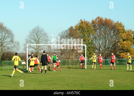 Fußballspiel im Gange auf dem grünen Dorfplatz Rückansicht des Schiedsrichters beim Jugendsport-Fußballspiel Mountnessing Brentwood Essex England Stockfoto