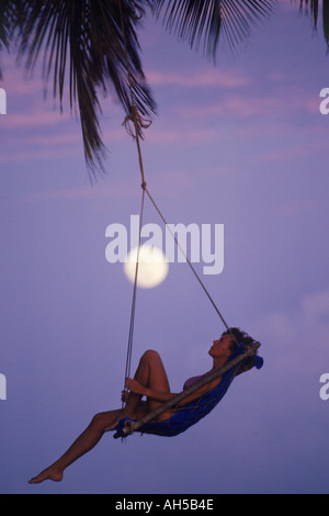 Frau in Gange hängen von Palme mit Vollmond Stockfoto