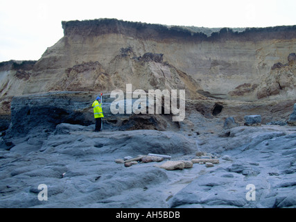 MÄNNLICHE PERSON, DIE EIN MESSGERÄT ZUR MESSUNG DER KLIPPENEROSION HÄLT, FÜR NORTH NORFOLK COUNCIL, HAPPISBURGH NORFOLK EAST ANGLIA ENGLAND UK Stockfoto