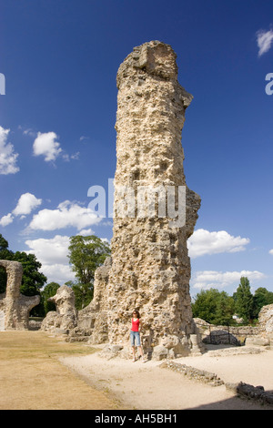 Eine Frau steht neben der riesigen Spalte der Überreste der Abtei von Bury St Edmunds in Suffolk, UK Stockfoto