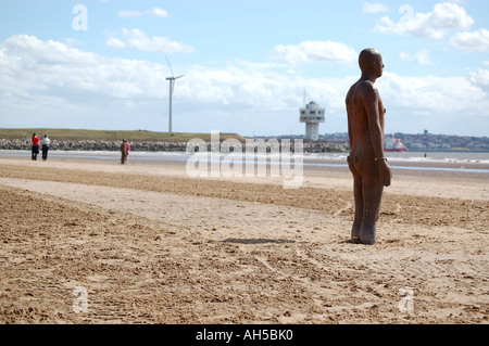 Ein Eisen-Mann-Statue von Antony Gormley Ausstellung "Woanders" Crosby Beach, Liverpool in Merseyside installiert Stockfoto