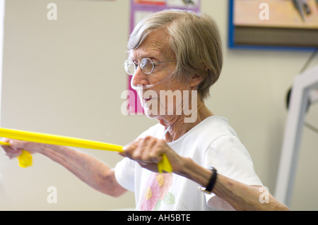 erschöpft, 80 Jahre alte Frau geht durch Training in einem Krankenhaus-Reha-Fitnessstudio Stockfoto