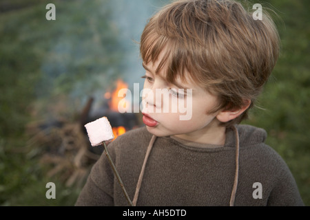 Junge mit Marshmallow am stick Stockfoto