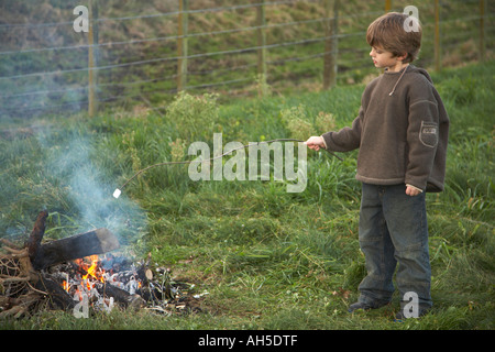 Kind Toasten Marshmallow am offenen Feuer außerhalb Stockfoto