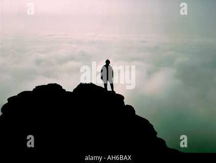 Silhouette der Figur auf Berggipfel über den Wolken Stockfoto