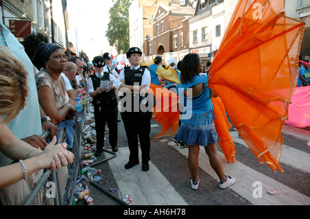 Junge schwarze Polizist Teilnahme in Notting Hill Karneval als Darsteller tanzen und ihn zu necken. Stockfoto