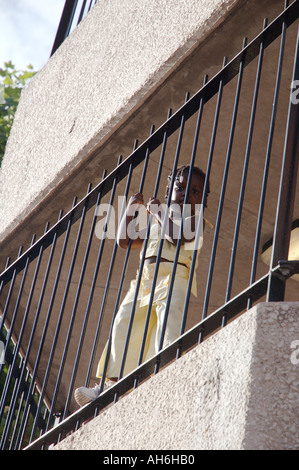 Kleines Kind hängen auf Geländer vom Balkon Obergeschoss des Highrise flach. Stockfoto