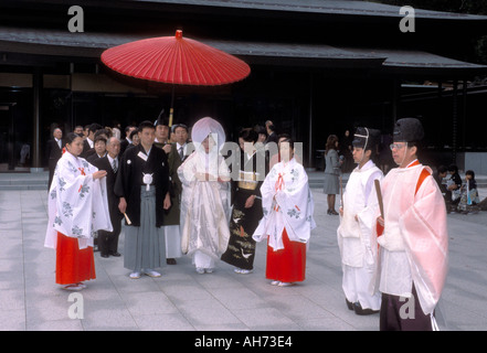 Eine traditionelle Hochzeitsprozession mit Braut, Bräutigam und Priestern im Kimono, die ihren Weg durch den Meiji Jingu-Schrein in Tokio, Japan, machen. Stockfoto