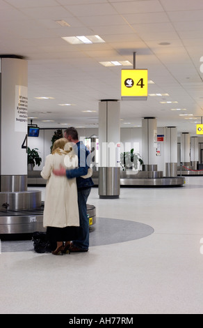 Paar am Flughafen umarmen Stockfoto