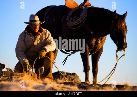 Reifer Mann mit einem Pferd neben ihm kniend Stockfoto