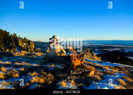 Reifer Mann sitzt vor einem Lagerfeuer Stockfoto