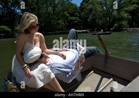 Junge Frau sitzt in einem Boot mit einem jungen Mann auf ihrem Schoß Stockfoto