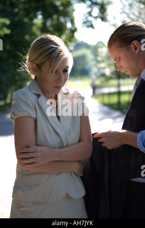 Junge Frau, die Arme gekreuzt, neben einem jungen Mann Stockfoto