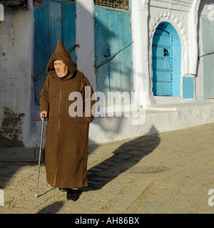 Traditionell gekleidet Alter Mann zu Fuß in blau gewaschenen Straßen von Chefchaouen Marokko Nordafrika Stockfoto
