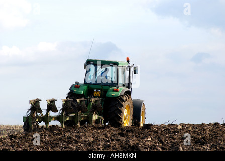 John Deere Traktor Pflügen Stoppeln Field, Warwickshire, England, UK Stockfoto