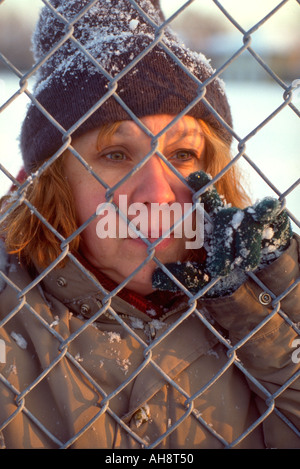 Obdachlose Frau Alter 50 spähte durch Maschendrahtzaun.  St Paul Minnesota USA Stockfoto