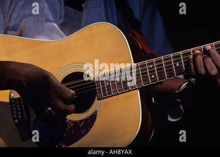 Schwarzer Musiker, der auf der Straße entlang des AVE University District in Seattle, Washington, USA, Gitarre spielt Stockfoto