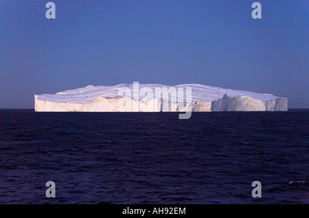 Riesige flache Eisberg im Frührot Licht reflektierenden weißen in einem dunklen Marineblau Meer in der Disko-Bucht vor der Westküste Grönlands einseitig Stockfoto