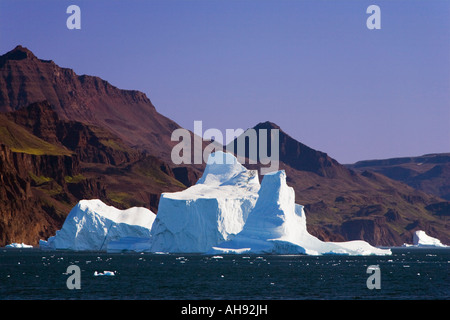 Großen Eisbergs kontrastierenden gegen karge Klippen der Diskoinsel auf eisigen Meer vor Qeqertarsuaq auf West Küste von Grönland Stockfoto