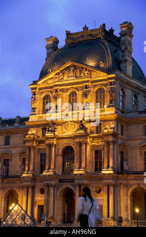 Abend im Musée du Louvre in Paris Frankreich mit einer Frau zu Fuß in den Vordergrund Stockfoto