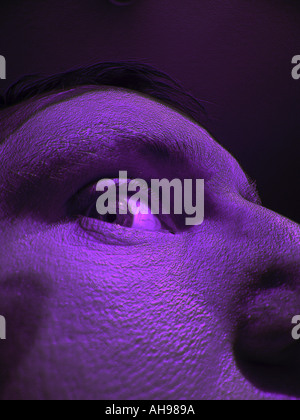 Seltsame Mann s Gesicht Nahaufnahme mit Auge violett Stockfoto