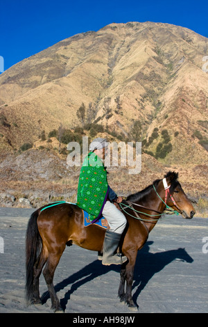 Tengger-Mann auf dem Pferd vor Mt Batok warten auf Touristen bis zum Rand des Gunung Bromo oder Mount Bromo Java Indonesien nehmen Stockfoto