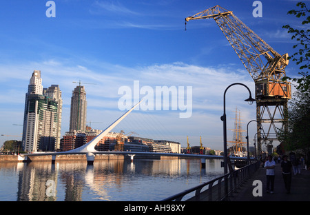 Puerto Madero und Brücke der Frau Ansicht an bewölkten Tag mit Wasserspiegelungen, Passanten und dock-Kran. Stockfoto