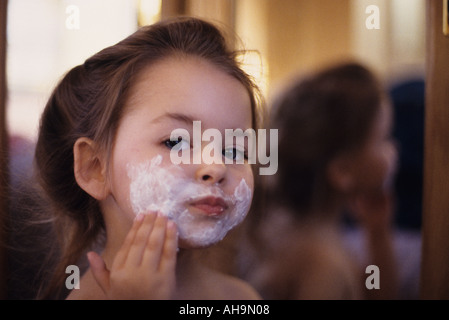 Junges Mädchen in Spiegel aufsetzen Rasierschaum Stockfoto