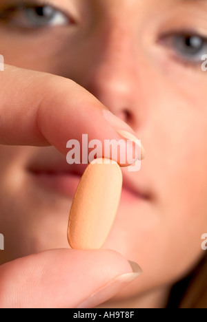 Kapsel zwischen den Fingern halten Stockfoto