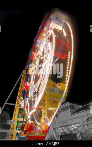 Das Riesenrad dreht sich in eine bunte Mischung aus Licht Stockfoto