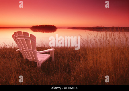 Liegestuhl, Blick auf See bei Sonnenuntergang; Astotin Lake, Elk Island Park, Alberta, Kanada Stockfoto