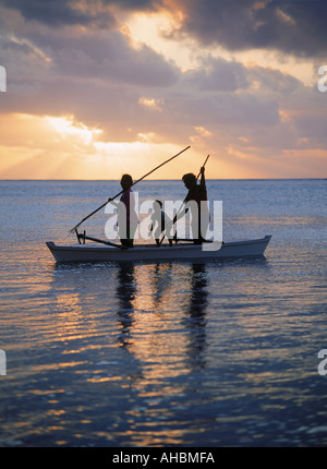 Familie im Auslegerkanu spearfishing auf Insel Aitutaki Lagune auf den Cook Inseln bei Sonnenuntergang Stockfoto
