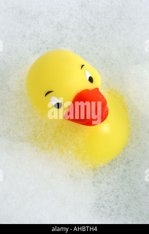 Eine einzelne gelbe Gummiente, die in den Blasen aus Schaumstoff im Schaumbad schwimmt Stockfoto