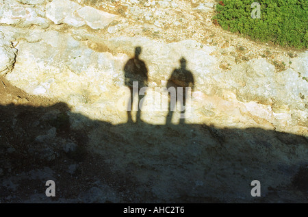 Die Schatten zweier Wanderer werfen sich an einem sonnigen Tag im Vereinigten Königreich auf felsigen Untergrund Stockfoto
