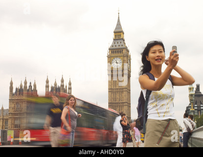 orientalische Frau, die ein digitales Mobiltelefon Selbstbildnis auf Westminster Bridge mit Big Ben und London Bus Stockfoto